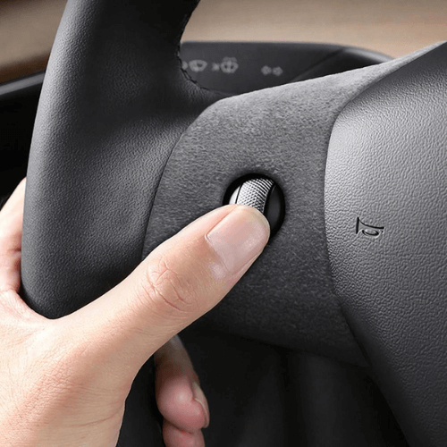 Image of a hand pressing a button on a covered steering wheel, enhancing comfort in Tesla Model 3 or Model Y.