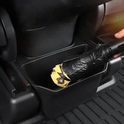 Bac de rangement pour passagers arrière de Tesla, accueillant un parapluie plié.