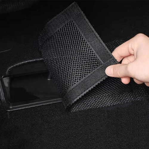 Protection d'aérateurs pour Tesla, main tenant un accessoire en mesh noir pour couvercle d'aérateur.