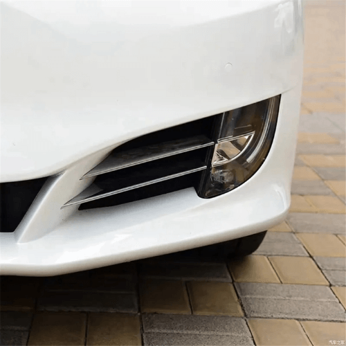 Close-up of a white Tesla Model S front end featuring OEM-style LED turn signal lights.
