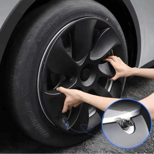 Person installing a 19-inch wheel cover on a Tesla, showcasing stylish design and quality craftsmanship.