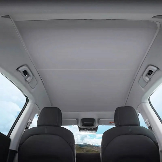 Intérieur d'un véhicule avec toit vitré offrant une vue dégagée, mettant en avant le confort et le style.