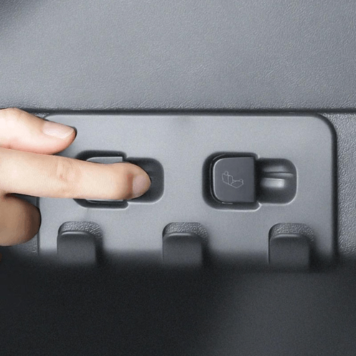 Main interface for activating the cargo hooks in a Tesla, showcasing a hand pressing the button.