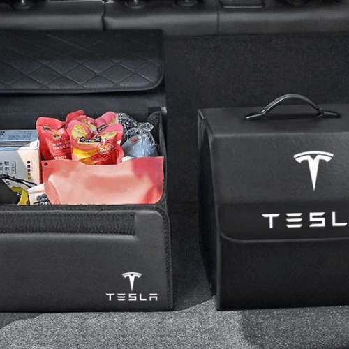 Boîtes de rangement Tesla dans un coffre, offrant une organisation intelligente pour accessoires et courses.