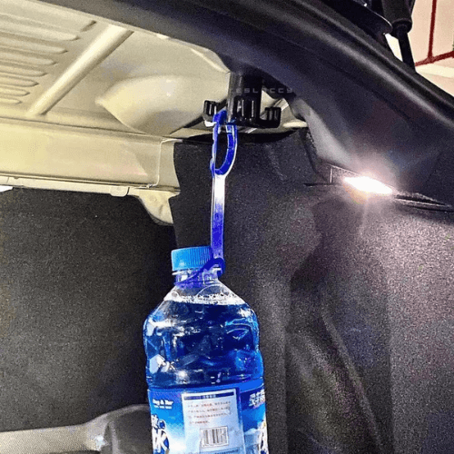 Crochet d'arrimage de coffre Tesla avec bouteille d'eau suspendue, facilitant l'organisation de votre espace de chargement.