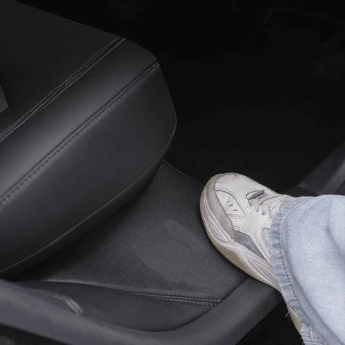 Protection de base de siège Tesla Model Y avec un pied posé, montrant durabilité et confort.