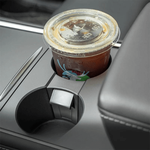 Support pour porte-gobelets Tesla avec une boisson, design élégant intégré à l'intérieur de la voiture.