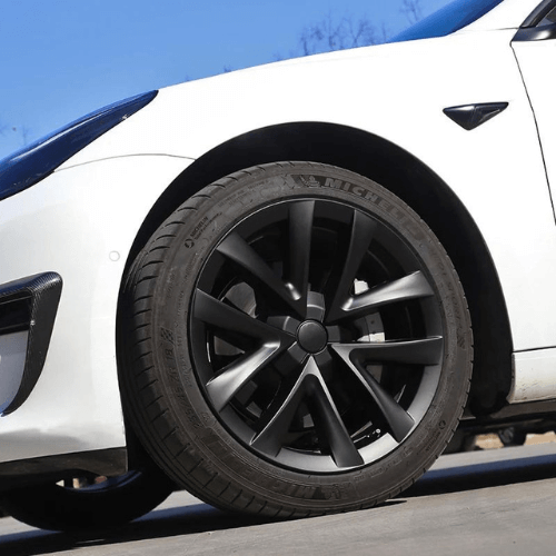 Close-up of Tesla Model 3 with stylish 18-inch black wheel and tire showcasing modern design and durability.