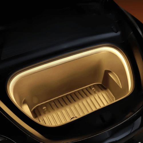 Illuminated front trunk of a Tesla Model 3 and Y with LED lighting, showcasing a sleek storage space.