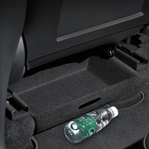 Bac de rangement sous sièges Tesla Model Y avec une bouteille d'eau, optimisant l'espace de rangement.