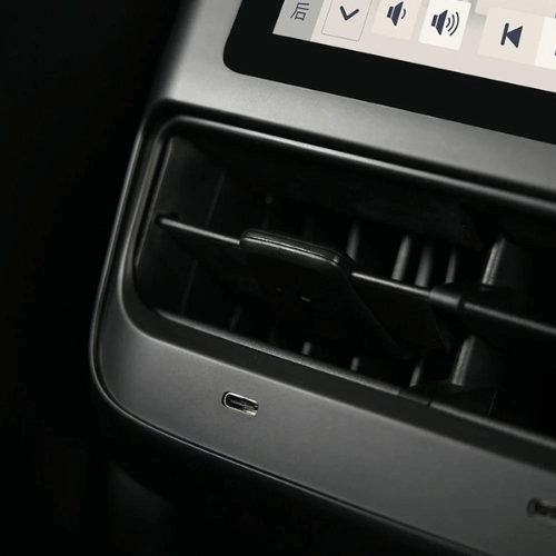 Close-up of Tesla Model 3 rear passenger LCD console with intuitive interface and charging port.