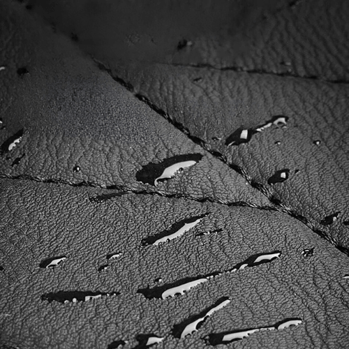 Gros plan sur un tapis de coffre en matériaux résistants et imperméables, avec des gouttes d'eau.