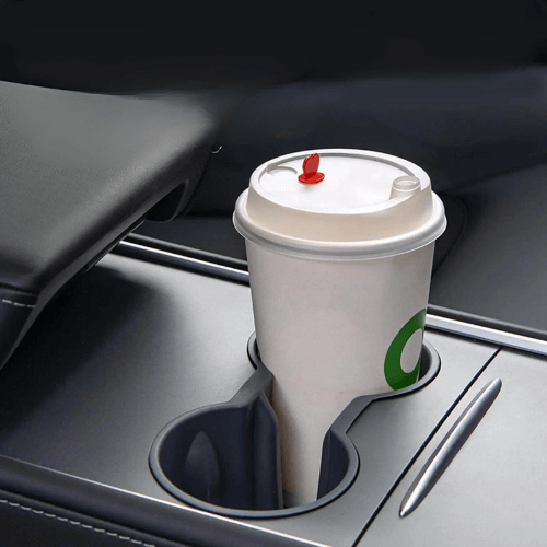 Protection de porte gobelet dans une Tesla avec un gobelet en papier, offrant style et fonctionnalité.