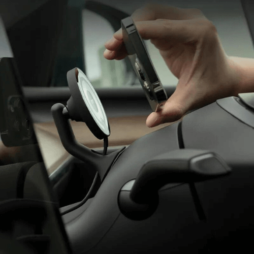 Person attaching a phone to a Tesla phone mount for safe, hands-free use while driving.