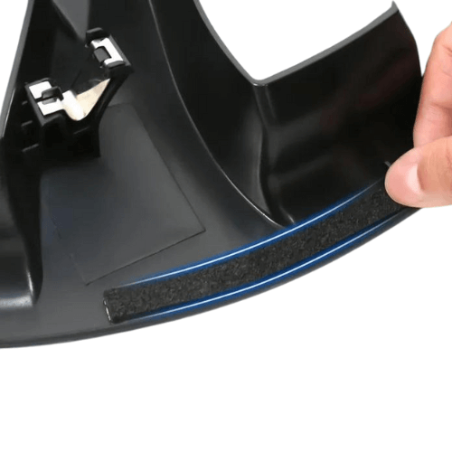 Close-up of a hand holding a 20-inch wheel cover with a blue trim, showcasing its design and material details.